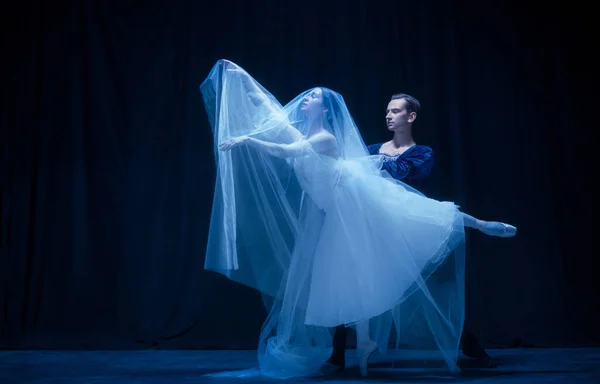 Jonge vrouw in trouwjurk en man, twee ballet dansers in kunst performance dansen geïsoleerd over donkere achtergrond. — Stockfoto