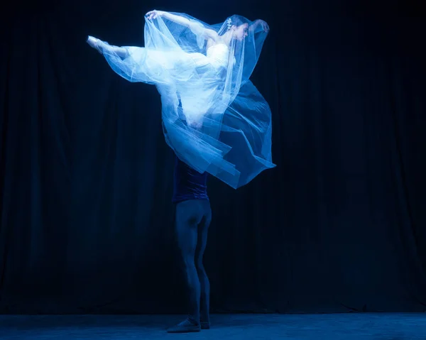 Jeune femme en robe de mariée et homme, deux danseurs de ballet en performance artistique dansant isolés sur fond sombre. — Photo