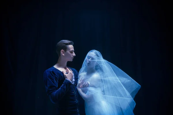 Mujer joven en vestido de novia y hombre, dos bailarines de ballet en performance de arte bailando aislados sobre fondo oscuro. —  Fotos de Stock