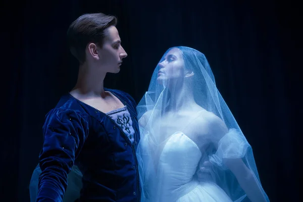 Jovem mulher em vestido de noiva e homem, dois dançarinos de balé em performance de arte dançando isolado sobre fundo escuro. — Fotografia de Stock