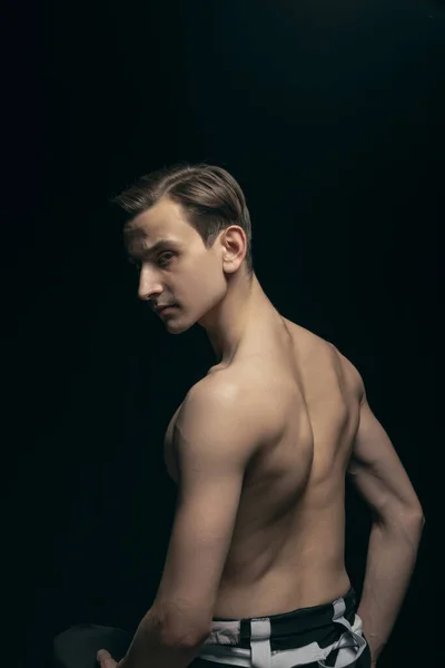 Portret van jonge knappe man, mode model poseren geïsoleerd op donkere achtergrond. Schoonheid, mode, inspiratie concept. — Stockfoto