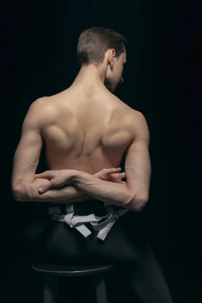 Retrato de un joven guapo, modelo posando aislado sobre un fondo oscuro. Belleza, moda, concepto de inspiración. —  Fotos de Stock