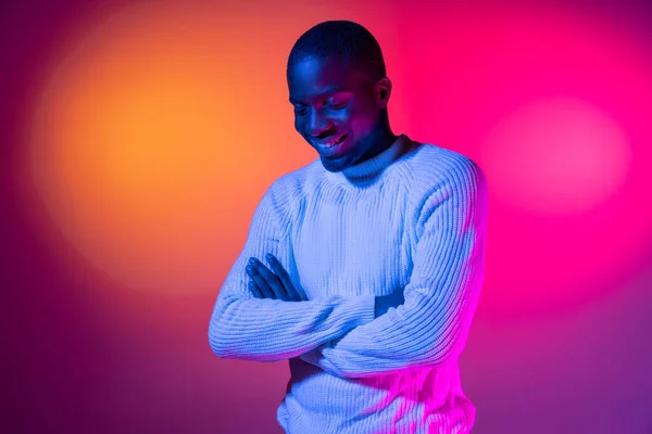 One young happy African handsome man isolated over gradient pink yellow neon background.