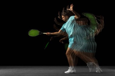 Stroboskop etkisi. Bir adam, profesyonel tenisçi, siyah arka planda karışık neon ışıkta izole edilmiş..