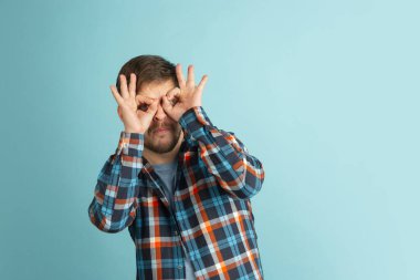 Açık mavi arka planda izole edilmiş günlük kıyafetler giyen komik, beyaz sakallı bir adam. Eğleniyorum..