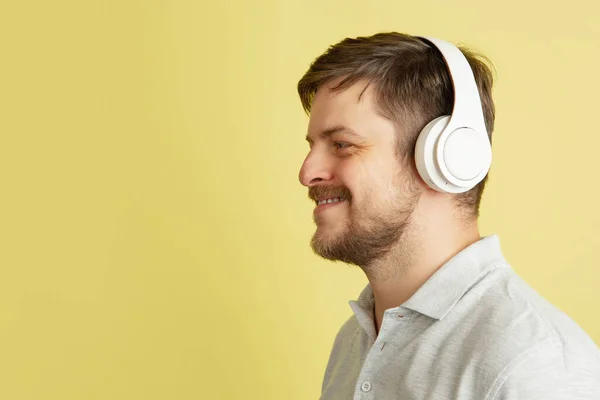 Seitenansicht eines jungen kaukasischen Mannes isoliert auf hellgelbem Hintergrund. Konzept der Mimik, der menschlichen Emotionen. — Stockfoto