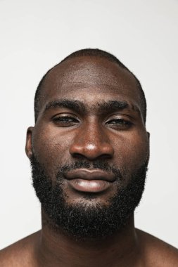 Beyaz arka planda izole edilmiş yakın plan Afrikalı genç adam. Güzellik anlayışı, kaplıca, iyi korunmuş deri.