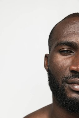 Beyaz arka planda soyutlanmış genç Afrikalı bir adamın yüzü. Güzellik anlayışı, kaplıca, iyi korunmuş deri.