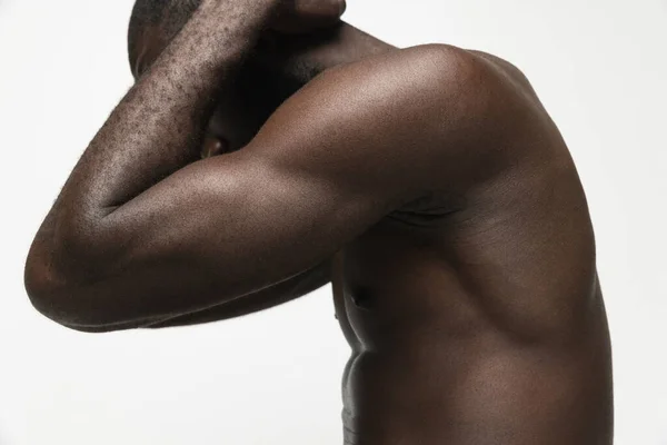 Retrato recortado de un apuesto hombre africano musculoso aislado sobre fondo blanco. Concepto de belleza, cosméticos, spa. — Foto de Stock