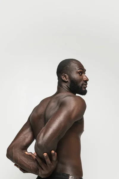 Porträtt av ung vacker muskulös afrikansk man poserar isolerad över vit bakgrund. Bakifrån — Stockfoto