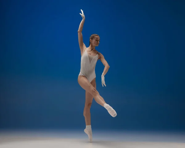 Joven hermosa bailarina en acción aislada sobre fondo azul. Concepto de belleza, arte, espectáculo, teatro. —  Fotos de Stock