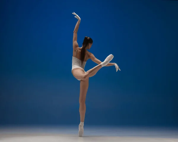 Mince tendre jeune belle fille, danseuse de ballet féminin dansant isolé sur fond bleu. — Photo