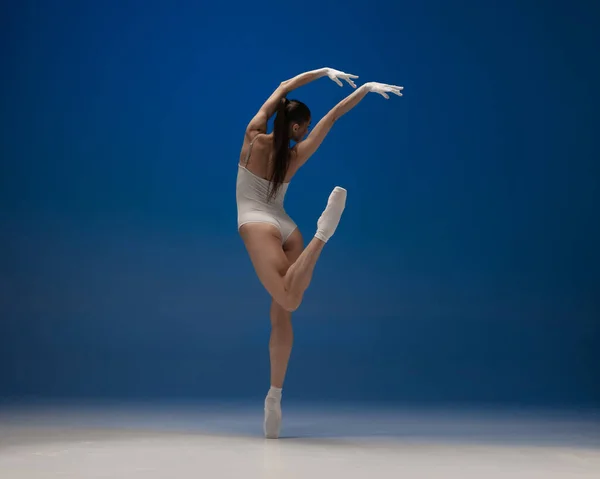 Jovem bela bailarina em ação isolada sobre fundo azul. Conceito de beleza, arte, espetáculo, teatro. — Fotografia de Stock