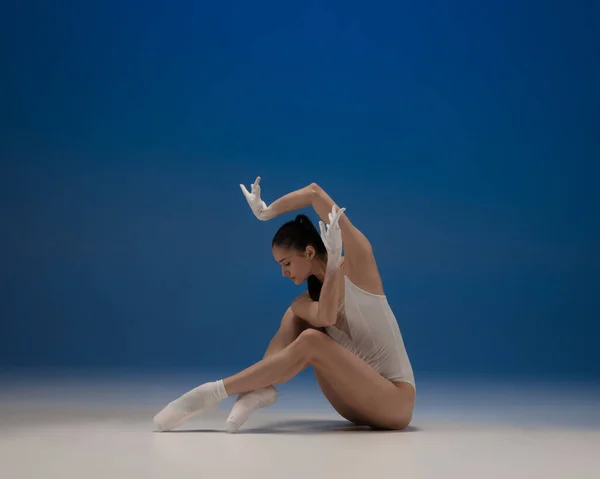 Joven hermosa bailarina en acción aislada sobre fondo azul. Concepto de belleza, arte, espectáculo, teatro. —  Fotos de Stock