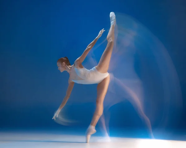 Belle jeune fille gracieuse, danseuse de ballet féminine dansant isolée sur fond bleu. Effet de réflexion — Photo