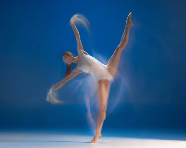 Χαριτωμένη νεαρή όμορφη κοπέλα, χορεύτρια μπαλέτου που χορεύει απομονωμένη σε μπλε φόντο. Αποτέλεσμα αντανάκλασης — Φωτογραφία Αρχείου