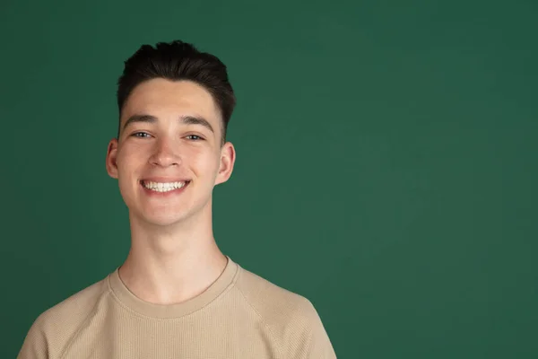 Portrait of young Caucasian boy isolated on green studio background. Concept of facial expressions, human emotions. — Stock Photo, Image