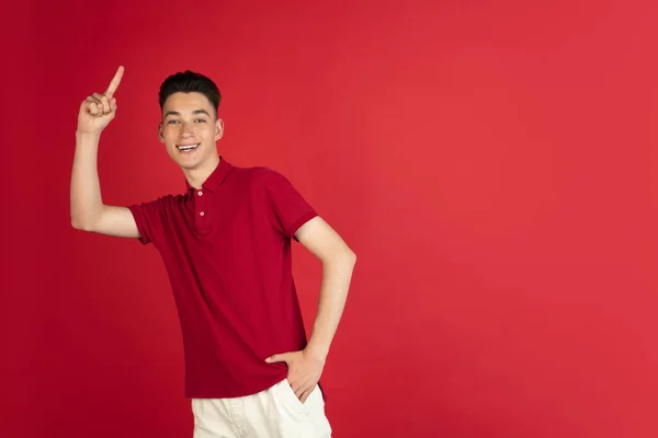 Un joven chico caucásico aislado en el fondo rojo del estudio. Concepto de expresiones faciales, emociones humanas. —  Fotos de Stock