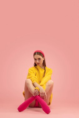 Genç güzel bir kızın portresi, pembe arka planda izole edilmiş kadın bale eğitimi..