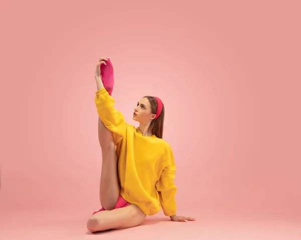 Flexible young beautiful girl, female ballet dancer training isolated over pink background. — Stock Photo, Image