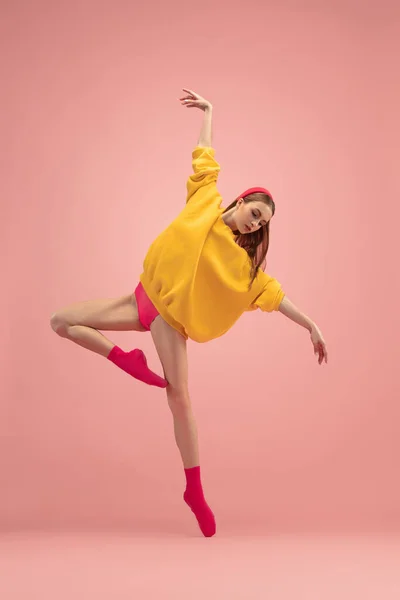 Slim tender young beautiful girl, female ballet dancer dancing isolated over pink background. — Stock Photo, Image