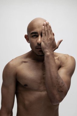 Yakından yakışıklı kaslı Afrikalı adam beyaz arka planda yalnız poz veriyor. Güzellik kavramı, kozmetik, kaplıca.