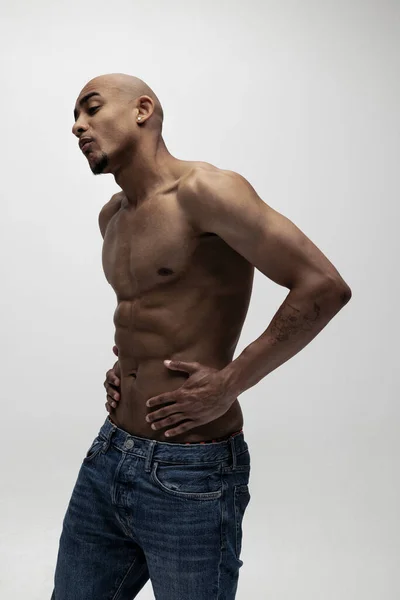 Porträtt av ung muskulös afrikansk man, mode modell isolerad över vit bakgrund. — Stockfoto