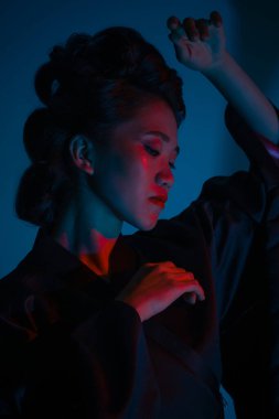 Genç ve güzel bir Japon 'un portresi. Ulusal giyimli bir kadın. Koyu mavi arka planda soyutlanmış bir şekilde poz veriyor..