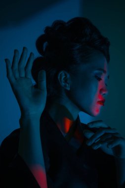 Genç ve güzel bir Japon 'un portresi. Ulusal giyimli bir kadın. Koyu mavi arka planda soyutlanmış bir şekilde poz veriyor..