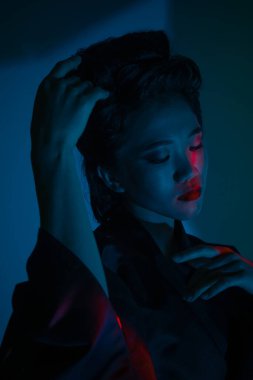 Genç ve güzel bir Japon 'un portresi. Ulusal giyimli bir kadın. Koyu mavi arka planda soyutlanmış bir şekilde poz veriyor..