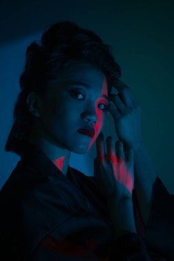 Genç ve güzel bir Japon 'un portresi. Ulusal giyimli bir kadın. Koyu mavi arka planda soyutlanmış bir şekilde poz veriyor..