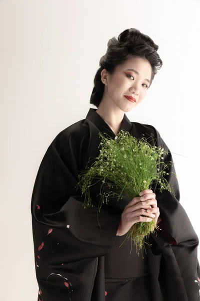 若い美しい日本人の肖像、白いスタジオの背景に隔離されたポーズをとる民族衣装の女性. — ストック写真