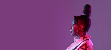 Genç, güzel, mutlu Afrikalı bir kız. Mor bir arka planda izole edilmiş. El ilanı