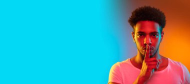 Stüdyodaki genç bir Afrikalı 'nın portresi. Renkli parlak neon ışıklarda moda erkek modeli.