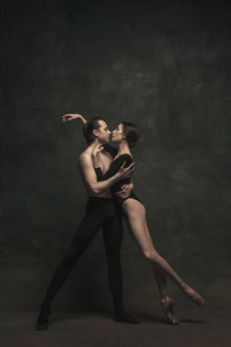 Güzel, zarif kadın ve erkek, sanat performansı dansçıları karanlık arka planda izole edilmiş.