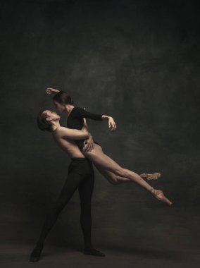 Güzel, zarif kadın ve erkek, sanat performansı dansçıları karanlık arka planda izole edilmiş.