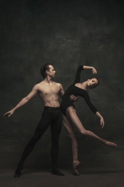 Güzel, zarif kadın ve erkek, sanat performansı dansçıları karanlık arka planda izole edilmiş.