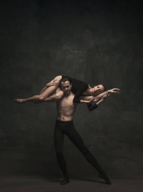 Güzel, zarif kadın ve erkek, sanat performansı dansçıları karanlık arka planda izole edilmiş.