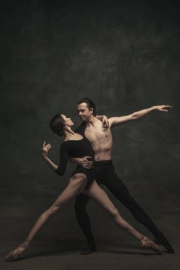 Güzel, zarif kadın ve erkek, sanat performansı dansçıları karanlık arka planda izole edilmiş.