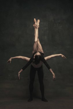 Güzel, zarif kadın ve erkek, sanat performansı dansçıları karanlık arka planda izole edilmiş.