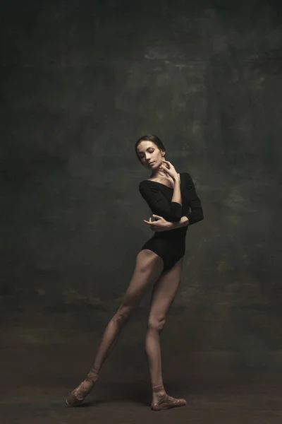 Dançarina de balé jovem e graciosa isolada em fundo escuro. Arte, movimento, ação, flexibilidade, conceito de inspiração. — Fotografia de Stock