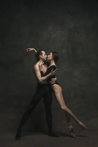 Hermosa mujer elegante y hombre, bailarines de ballet en performance de arte bailando aislados sobre fondo oscuro — Foto de Stock