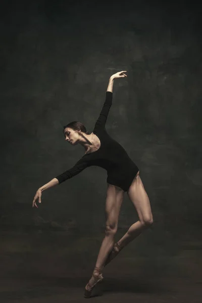 Joven y elegante bailarina de ballet aislada sobre fondo oscuro. Arte, movimiento, acción, flexibilidad, concepto de inspiración. —  Fotos de Stock