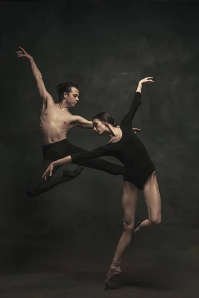 Hermosa mujer elegante y hombre, bailarines de ballet en performance de arte bailando aislados sobre fondo oscuro — Foto de Stock