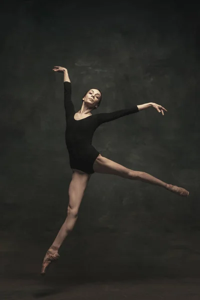 Dançarina de balé jovem e graciosa isolada em fundo escuro. Arte, movimento, ação, flexibilidade, conceito de inspiração. — Fotografia de Stock