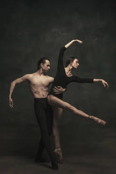 Hermosa mujer elegante y hombre, bailarines de ballet en performance de arte bailando aislados sobre fondo oscuro — Foto de Stock