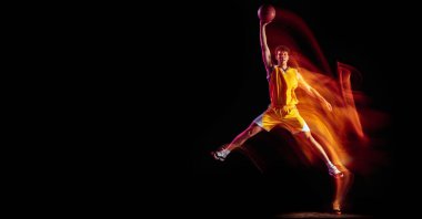Beyaz tenli genç basketbolcu eğitimi karışık neon ışıklarla siyah arka planda izole edildi. El ilanı