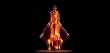 Genç beyaz basketbolcu eğitimi karışık neon ışıklarda siyah arka planda izole edildi.