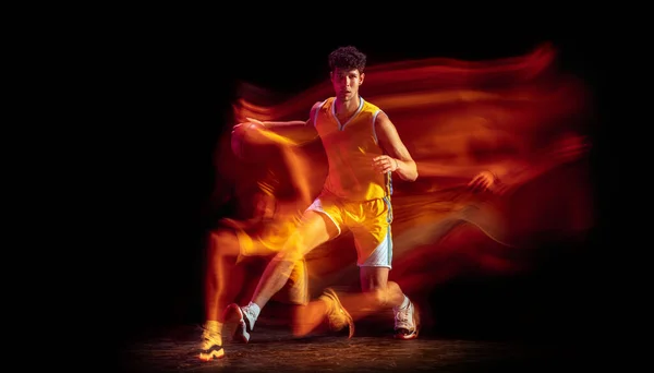 Молодий кавказький професійний баскетболіст, ізольований на чорному фоні змішаними неоновими вогнями.. — стокове фото