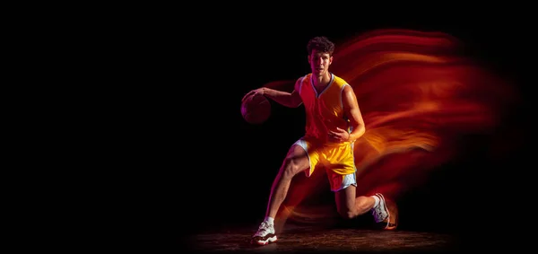 Giovane giocatore di basket professionista caucasico esercizio isolato su sfondo nero in luci al neon misti. — Foto Stock